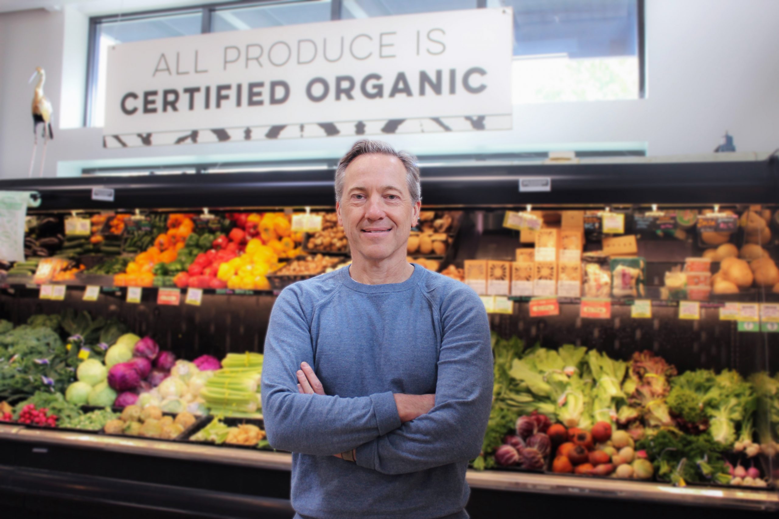 Photograph of Scott Nash standing in the produce section of a MOM's Organic Market