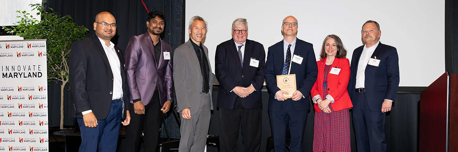 Physics Professor Wolfgang Losert, one of the winners of UMD's Invention of the Year competition, holds a plaque onstage at Innovate Maryland on Tuesday. Also pictured (from left): UM Ventures Innovation Managers Virinchi Juttukonda and Ashwin Ramanujam, Chief Innovation Officer Dean Chang, Vice President for Research Gregory F. Ball, UM Ventures Associate Director Felicia Metz and UM Ventures-College Park Director Ken Porter. Photos by Mike Morgan.