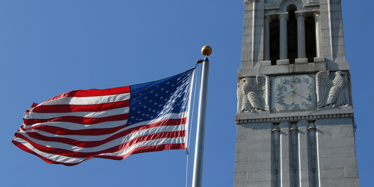 American flag in front for a stone tower.