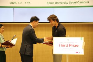 Nicholas Schiavone shakes hands with an organizer while receiving a certificate during the Climate Corps Summer School award presentation.