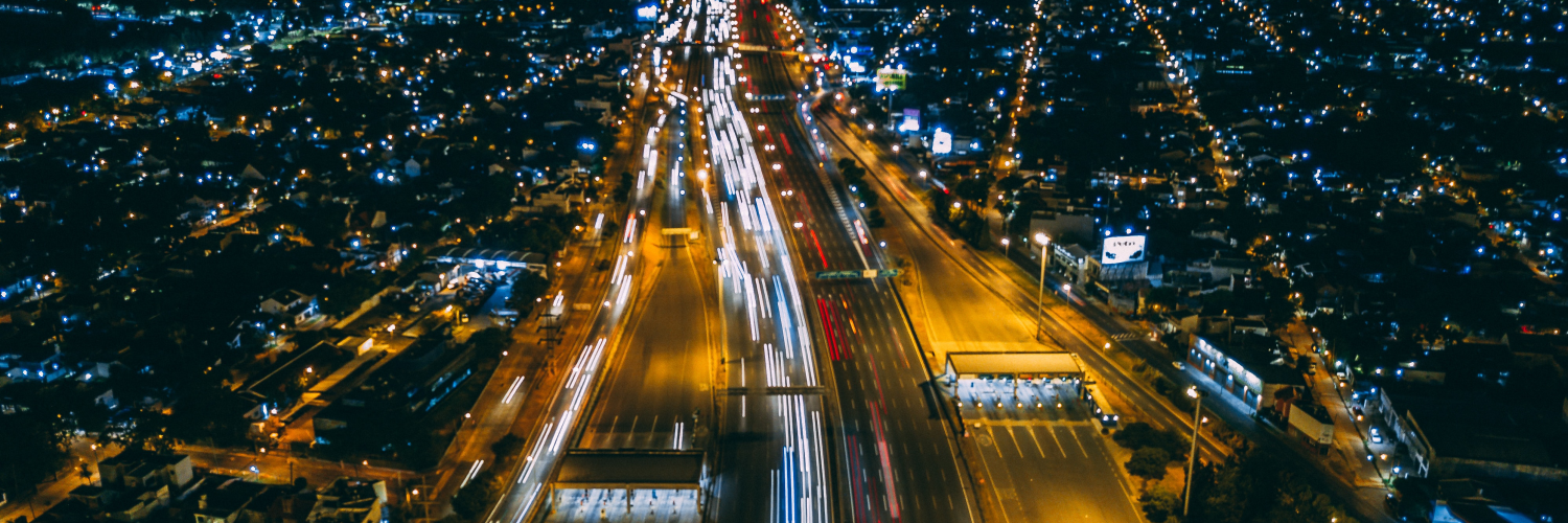 Image of a highway at night with a blur of lights from cars and street lamps