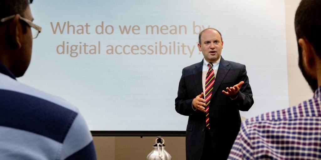 Dr. Jonathan Lazar giving a presentation with a slide that reads: "What do we mean by digital accessibility?
