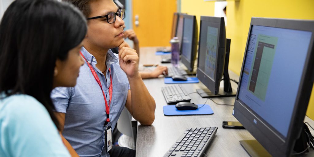 two people looking at a computer