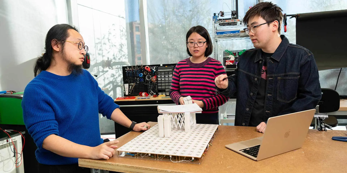 Working in the Small Artifacts (SMART) Lab, Assistant Professor of computer science Huaishu Peng (left) and doctoral students Zining Zhang (center) and Jiasheng Li discuss technology that can assist sight-impaired people.