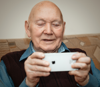 older man holding an iPhone horizontally