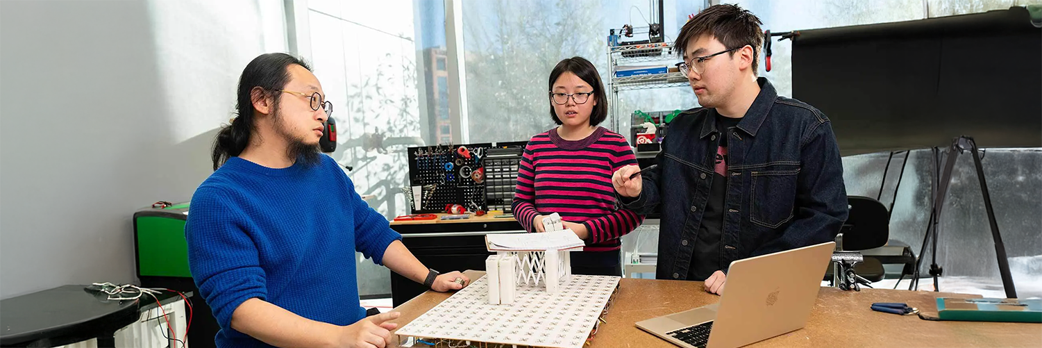 Working in the Small Artifacts (SMART) Lab, Assistant Professor of computer science Huaishu Peng (left) and doctoral students Zining Zhang (center) and Jiasheng Li discuss technology that can assist sight-impaired people.