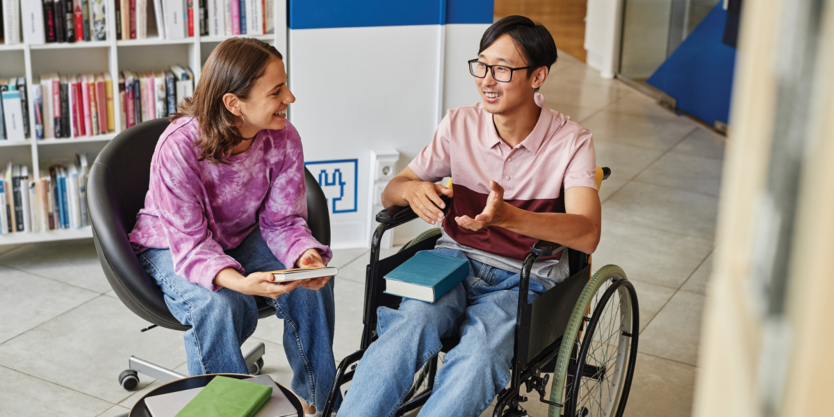 Two people talking, one of whom is using a wheelchair