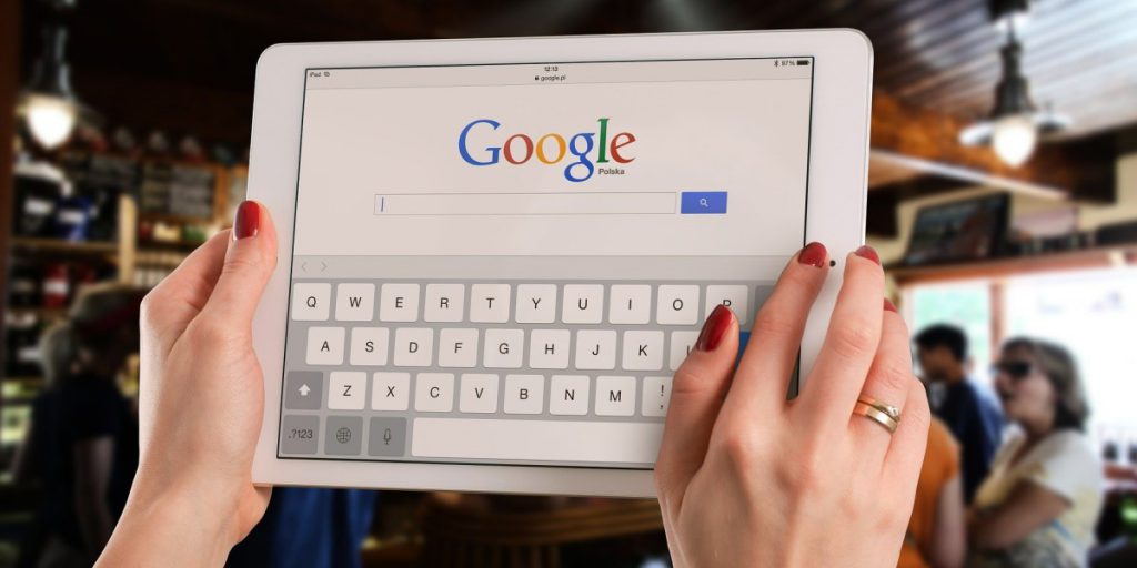 two hands on either side on an ipdad with the Google search bar in view