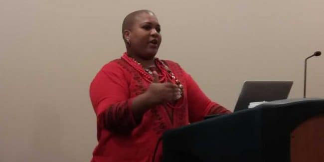 Ana Ndumu speaking behind a podium