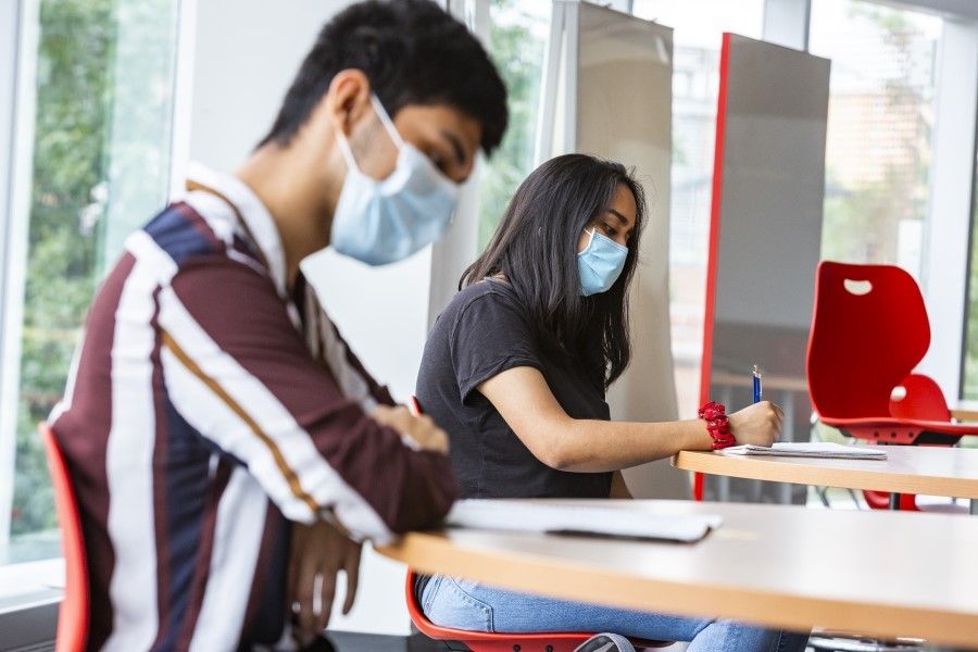 Students looking at coursework in a class.