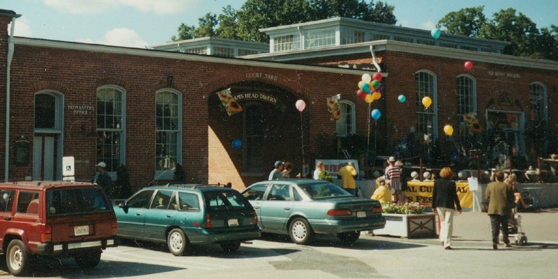 image of cars inn from of a building with balloons