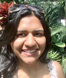 Gagan Jindal pictured with plants in the background smiling at the camera