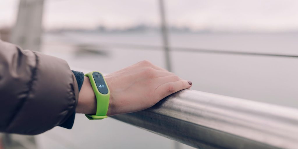 hand on rail with a green digital watch