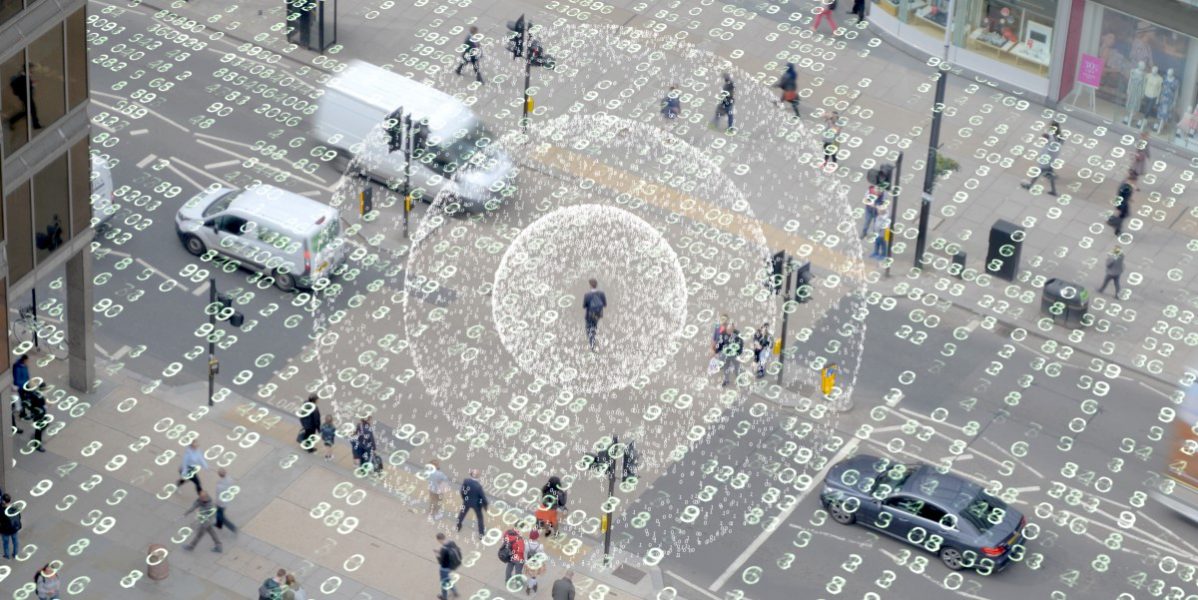 Photo augmented by computer graphics to show a man walking down a city street on his phone, which is emitting data into the air