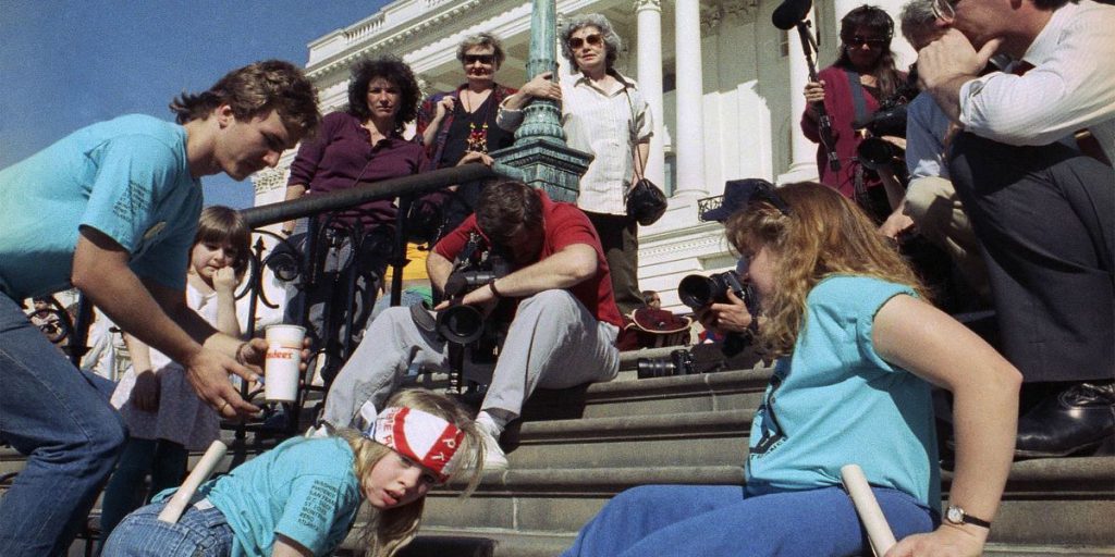 crowd of people on a set of steps with one person recording