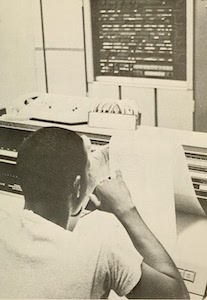 black and white photo of man sitting at a table in the The High John Library