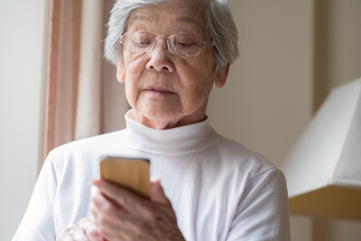 older woman looking down at a phone