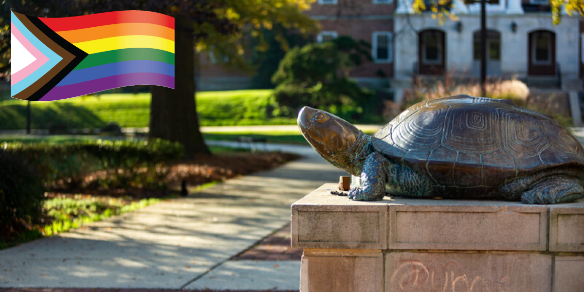 Image of Testudo statue on a sunny day with a pride flag imposed in the upper left corner